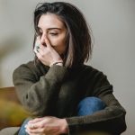depressed woman sitting in room